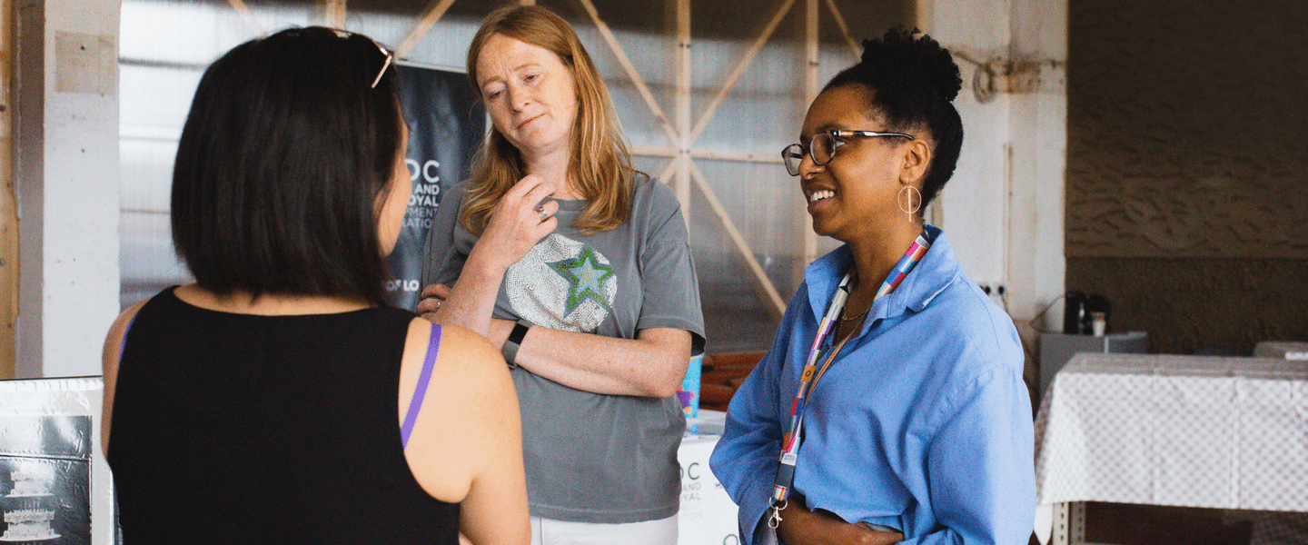 Three people chatting in a warehouse setting