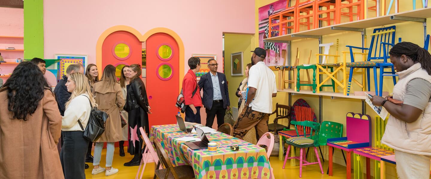 Image of people viewing artworks and future in brightly coloured studio