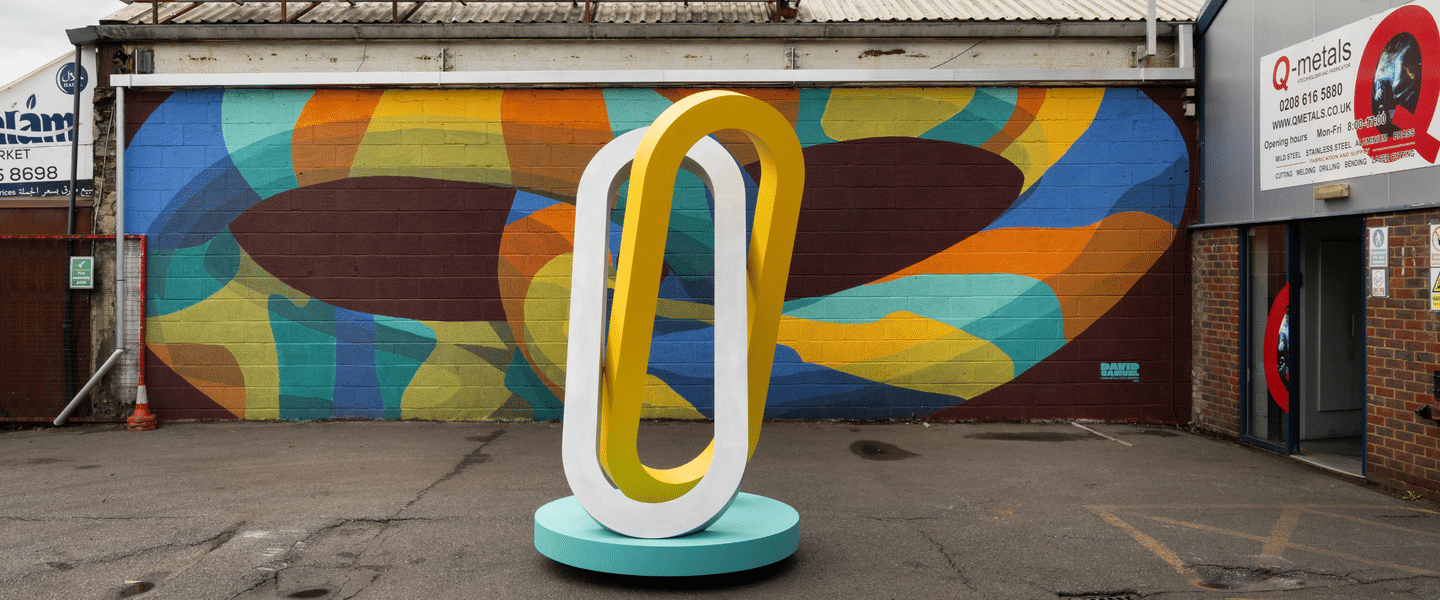 Image of two large metal chains interlinking and a large mural in the background