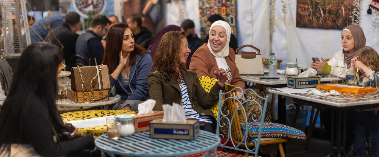 Image of a cafe with middle eastern tapestries and furniture and groups of women chatting