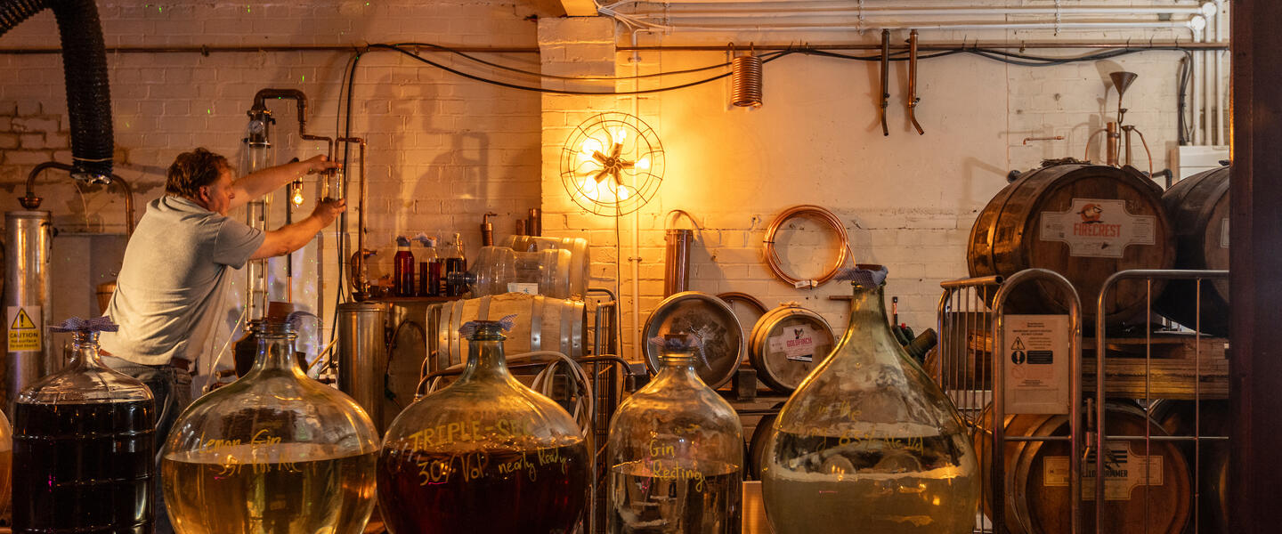 Image of different types of alcohol being distilled in a rustic setting