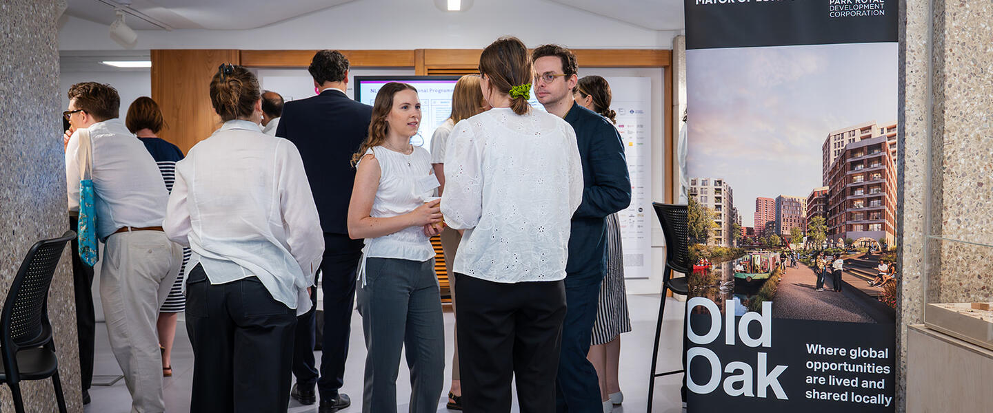 Image of a group of people networking alongside a banner with the words Old Oak on