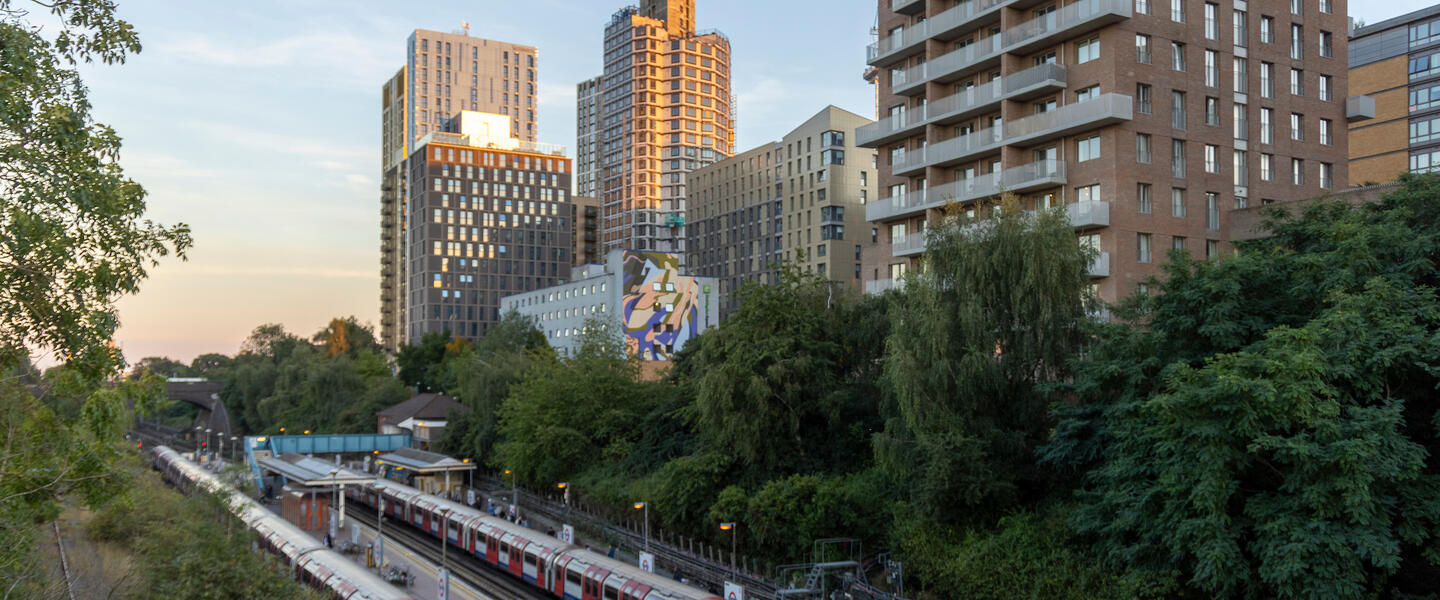 North Acton tube station and railway tracks, with skyscrapers in the background