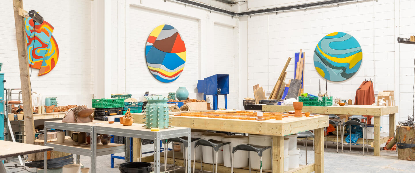 Image of a creative workspace, with work benches and art on the walls