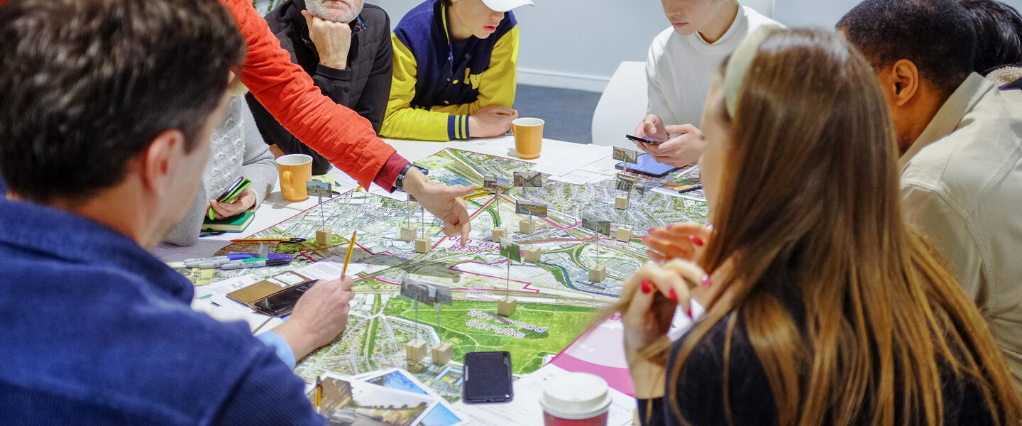 Image of a group of people looking at a map with places marked out