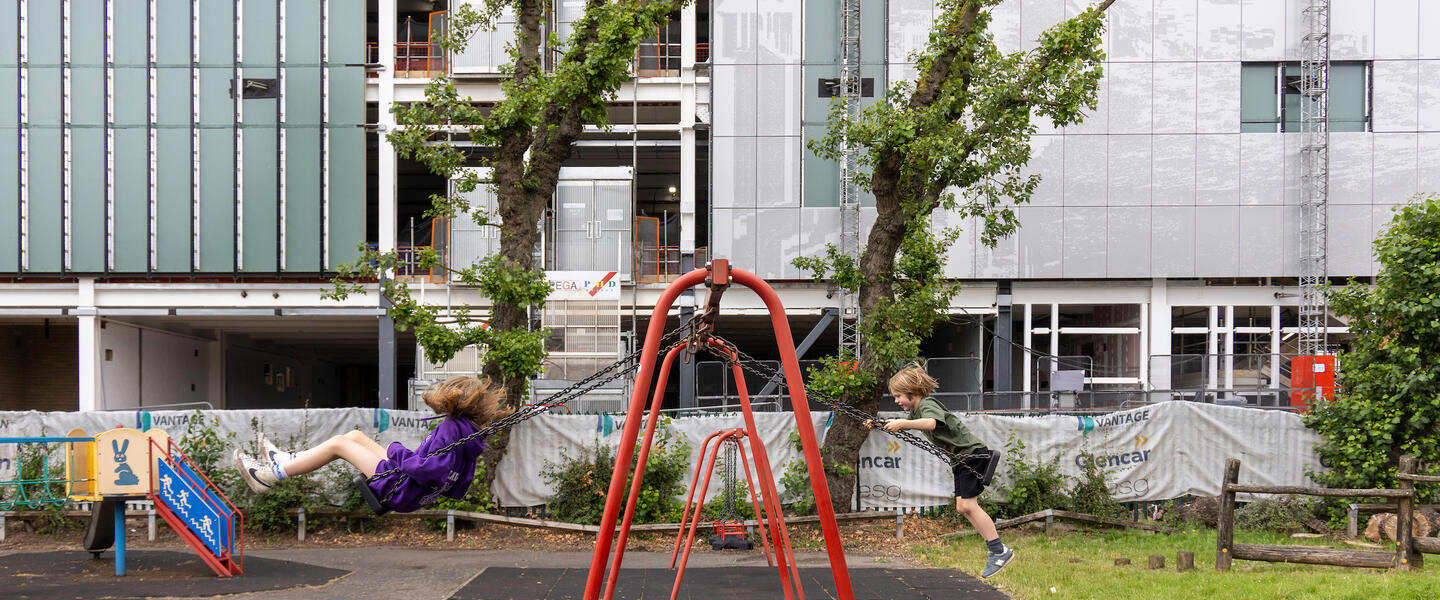 Image of two children swinging on swings